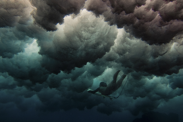 Underwater shot of a local female surfer from beneath the waves submerged diving photography
