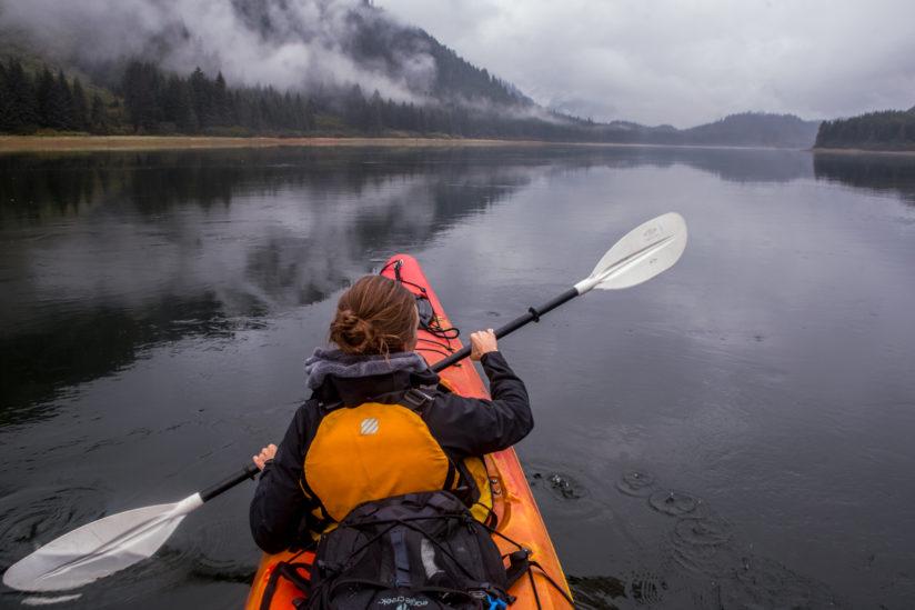 A woman kayaking in the Fjords of South Eastern Alaska.